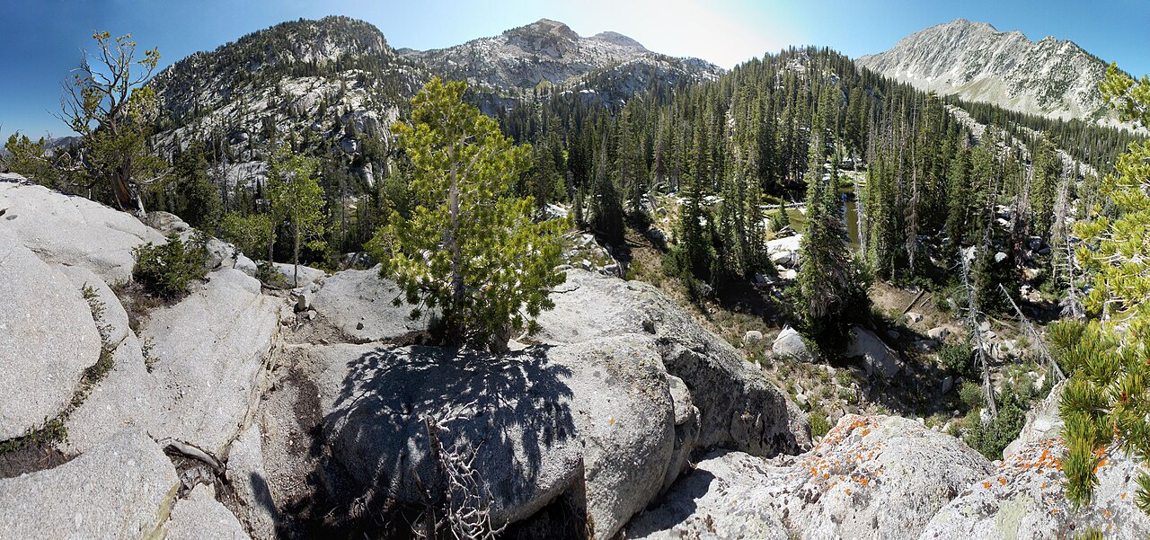 Panorama of upper Bells Canyon with granite benches, pines, and Lone Peak on the skyline